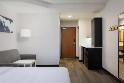a hotel room with a bed and a couch and a kitchen at Spark By Hilton Guelph in Guelph