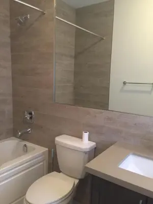 a bathroom with a toilet and a sink and a mirror at Comfortable private space in Pickering