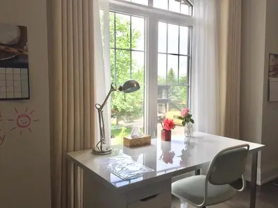a desk with a lamp and a chair in front of a window at Comfortable private space in Pickering