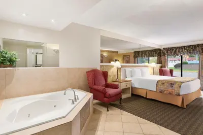 a hotel room with a bed and a bath tub at Travelodge by Wyndham Owen Sound ON in Owen Sound