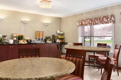 a restaurant with two tables and chairs and a kitchen at Travelodge by Wyndham Owen Sound ON in Owen Sound