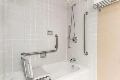 a bathroom with a bath tub with a chair in it at Travelodge by Wyndham Owen Sound ON in Owen Sound