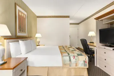 a hotel room with a bed and a flat screen tv at Travelodge by Wyndham Owen Sound ON in Owen Sound