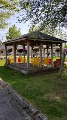 a gazebo with yellow tables and chairs in a park at Wasaga Beach Inn And Cottages in Wasaga Beach