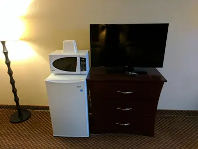 a microwave on top of a dresser with a refrigerator at Luxury Inn in Collingwood