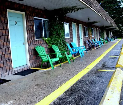 a row of green chairs sitting outside of a building at Cedar Lane Motel in Bracebridge