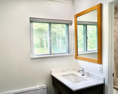 a bathroom with a sink and a mirror at Cedar Lane Motel in Bracebridge