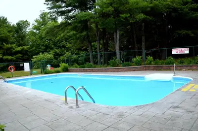 a large blue swimming pool with two metal rails at Cedar Lane Motel in Bracebridge