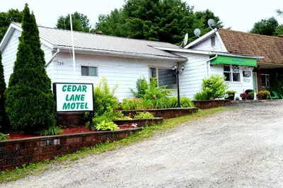 a house with a sign for a garden lane motel at Cedar Lane Motel in Bracebridge