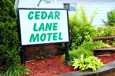 a sign for a garden lane motel in a yard at Cedar Lane Motel in Bracebridge