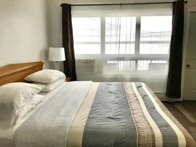 a bedroom with a large bed with a large window at Lakeside Inn in Orillia