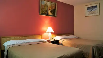 two beds in a room with red walls at Blue Jay Motel in Peterborough