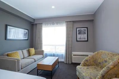 a living room with a couch and a chair at Sandman Hotel Hamilton in Hamilton