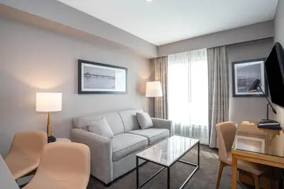 a living room with a couch and a tv at Sandman Hotel Hamilton in Hamilton