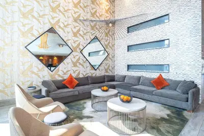 a living room with a couch and tables and a wall at Sandman Hotel Hamilton in Hamilton