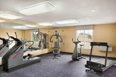 a gym with treadmills and elliptical machines at Days Inn by Wyndham Brantford in Brantford