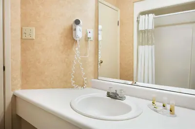 a bathroom with a sink and a mirror at Days Inn by Wyndham Brantford in Brantford
