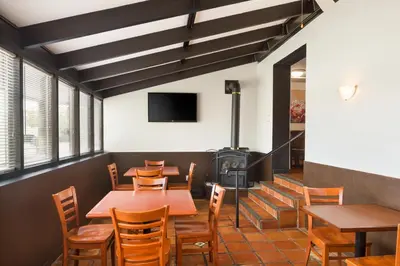 a restaurant with tables and chairs and a wood stove at Days Inn by Wyndham Brantford in Brantford