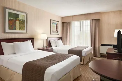 a hotel room with two beds and a television at Days Inn by Wyndham Brantford in Brantford