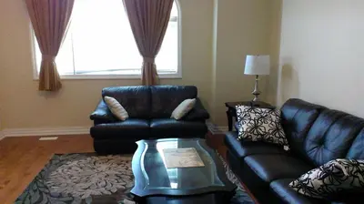 a living room with a leather couch and a chair at HB Guest Home 4 in Waterloo