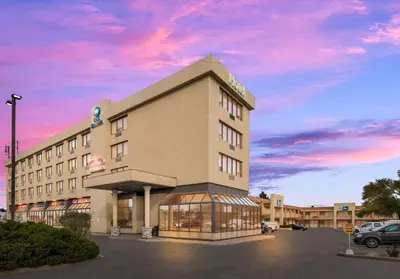 a hotel building with a sunset in the sky at Best Western Voyageur Place Hotel in Newmarket