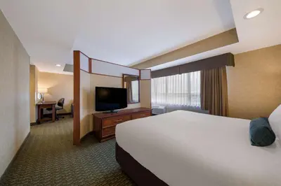 a hotel room with a bed and a flat screen tv at Best Western Voyageur Place Hotel in Newmarket