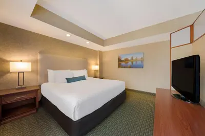 a hotel room with a bed and a flat screen tv at Best Western Voyageur Place Hotel in Newmarket