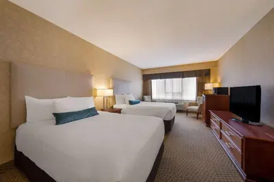 a hotel room with two beds and a television at Best Western Voyageur Place Hotel in Newmarket