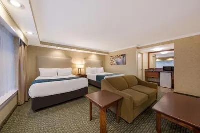 a hotel room with two beds and a couch at Best Western Voyageur Place Hotel in Newmarket