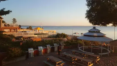 a park with benches and a gazebo next to the ocean at SunPort Beach Resort in Balm Beach