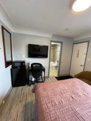 a hotel room with a bed and a desk and a television at Royal Inn in Burlington
