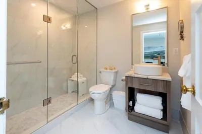 a bathroom with a shower and a toilet and a sink at The Glenerin Inn in Mississauga