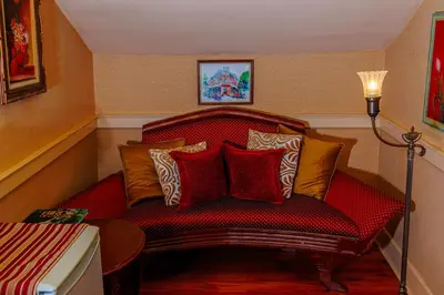 a red couch with pillows on it in a room at Historic Wilson-Guy House in Niagara on the Lake
