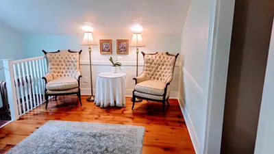 a hallway with two chairs and a table and two lamps at Historic Wilson-Guy House in Niagara on the Lake