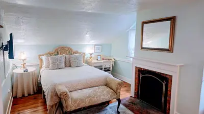 a bedroom with a bed and a fireplace at Historic Wilson-Guy House in Niagara on the Lake