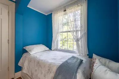 a blue room with a bed and a window at Chestnut Inn in Niagara Falls