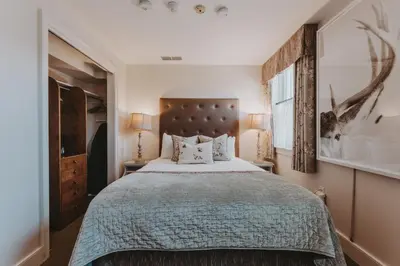 a bedroom with a large bed and two lamps at Moffat Inn in Niagara on the Lake