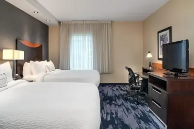 a hotel room with two beds and a flat screen tv at Fairfield Inn & Suites by Marriott Toronto Mississauga in Mississauga