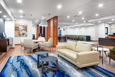 a living room with a couch and tables at Fairfield Inn & Suites by Marriott Toronto Mississauga in Mississauga