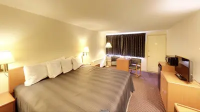 a hotel room with a large bed and a television at Travelers Inn in Belleville