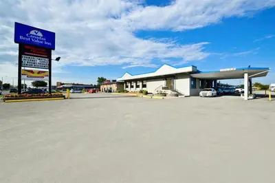 a large gas station with a sign in a parking lot at Travelers Inn in Belleville
