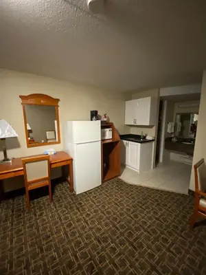 a kitchen with a refrigerator and a table and a counter at Angus Inn Motel in Angus