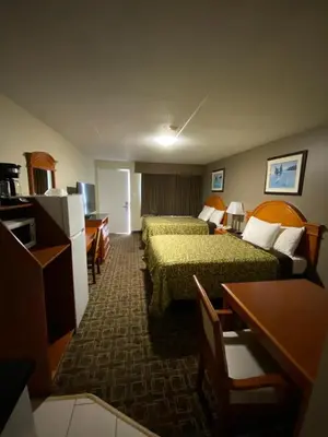 a hotel room with two beds and a desk at Angus Inn Motel in Angus