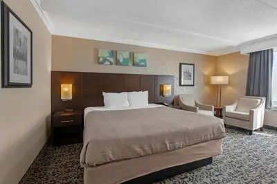a hotel room with a bed and a chair at Quality Inn & Conference Centre in Midland
