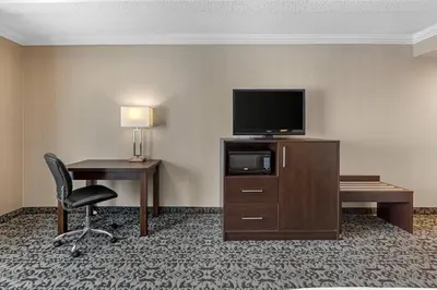 a hotel room with a desk and a television and a chair at Quality Inn & Conference Centre in Midland