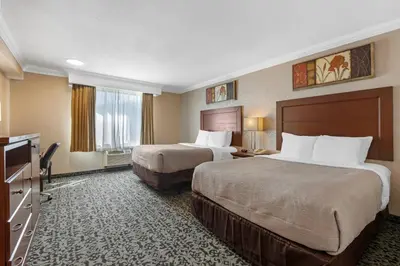 a hotel room with two beds and a television at Quality Inn & Conference Centre in Midland