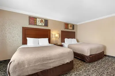 a hotel room with two beds and two lamps at Quality Inn & Conference Centre in Midland