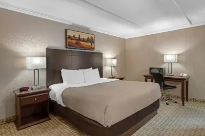 a hotel room with a bed and a desk at Quality Inn & Conference Centre in Midland