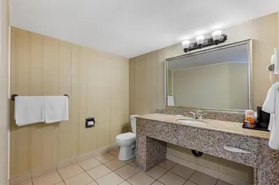 a bathroom with a sink and a toilet and a mirror at Quality Inn & Conference Centre in Midland