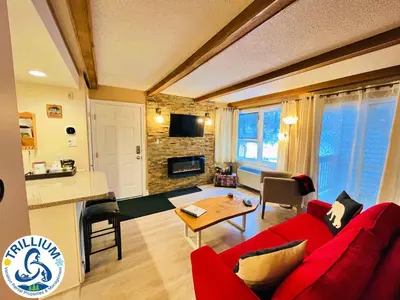 a living room with a red couch and a table at Rustic Mountainside Chalet in Blue Mountains